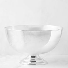 a silver bowl sitting on top of a white table