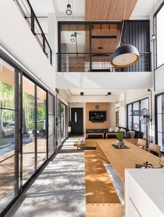 a large open floor plan with wooden floors and glass doors leading to the upper level