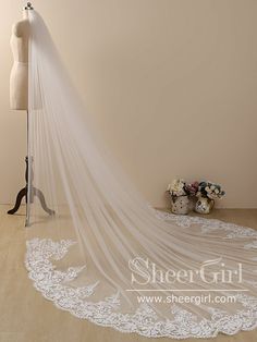 a wedding veil on a mannequin in front of a dress form with flowers