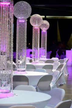 white tables and chairs are decorated with crystal balls