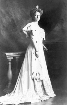 an old black and white photo of a woman in a dress with a tiara