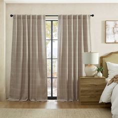 a bed room with a neatly made bed and curtains