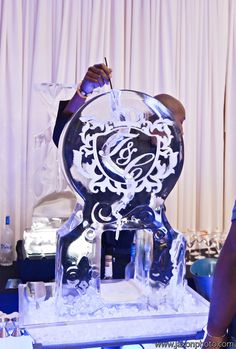 a man is writing on an ice sculpture that looks like it has been carved into the shape of a clock