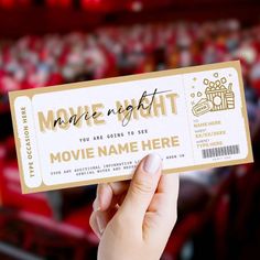 a person holding up a movie ticket in front of an audience