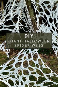 some white spider webs hanging from a tree in front of a house with the words diy giant halloween spider webs