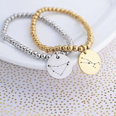 Show your stellar style with this Custom Constellation Stretch Bracelet! It's a unique "celestial" accessory, with a charm for each of the 12 astrological signs. Choose either silver or gold for a dazzling finish - and keep your star sign close to your heart. #outofthisworld! DETAILS: SIZES: S/M (5 to 6.5 inches) or M/L (6 to 7.5 inches) COLORS: stainless steel or yellow gold plated steel STYLE: beads on a stretchable cord, fits over hand CHARM: 5/8 inch (15mm) round Adjustable Personalized Celestial Jewelry, Adjustable Celestial Personalized Jewelry, Adjustable Celestial Bracelet For Gifts, Adjustable Celestial Style Bracelet Gift, Adjustable Celestial Bracelets As A Gift, Celestial Style Silver Metal Bracelets, Celestial Metal Bracelet For Gift, Adjustable Celestial Bracelet Gift, Celestial Adjustable Charm Bracelet Gift