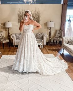 a woman is taking a selfie in her wedding dress while standing on the floor