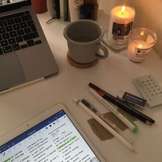 an open laptop computer sitting on top of a desk next to a cup of coffee