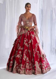 a woman in a red and gold wedding gown standing with her hands on her hips