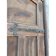 an old wooden door with metal hardware on it