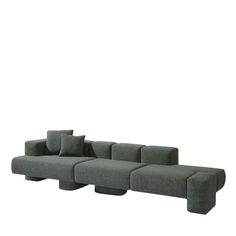 a large gray couch with pillows on the back and side, in front of a white background