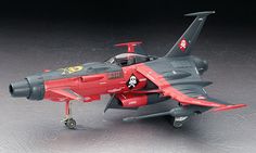 a red and black model airplane on a gray surface