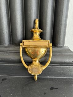 an ornate gold door handle on the side of a building