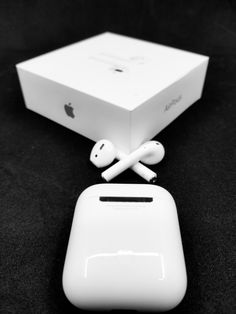 an apple product with its box and ear buds