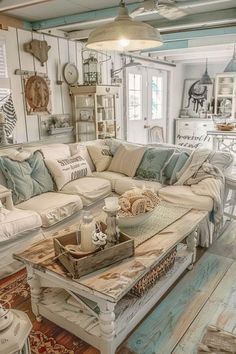 a living room filled with white furniture and lots of pillows on top of it's couch