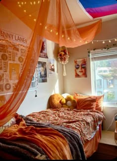 a bedroom with an orange bed cover and string lights hanging from it's ceiling