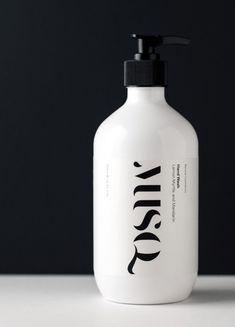 a white bottle with black lid sitting on top of a table