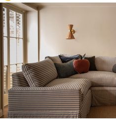 a striped couch with pillows on it in front of a window