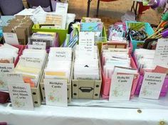 there are many cards and envelopes on display at the table with other items for sale