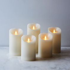 five lit candles with remote control on table