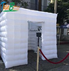 an inflatable tent is set up on the sidewalk for people to use it