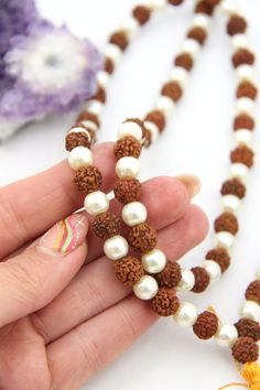 These beautiful beads are made from Rudraksha seeds paired with pearls. Hailing from India, Rudraksha seeds are traditionally used as prayer beads in Hinduism. They are the seeds of the Rudraksha tree, and legend has it that when Lord Shiva awoke from a long meditation, he shed a tear; from this tear grew the Rudraksha tree.Pearls are known as "moti" in Hindi, and they are symbolic of the moon. They encourage positive thinking and balance, and are believed to attract good luck and wealth. Bead S 8mm Beaded Mala For Festivals And Gifts, Mala With 8mm Beads As Festival Gift, White Gemstone Beads For Festivals, White Beaded Necklace As Diwali Gift, Traditional Pearl Necklace With Gemstone Beads, White Beaded Necklaces For Diwali Gift, White Beaded Necklace For Diwali Gift, White Mala With 8mm Beads For Rituals, Pearl Necklace With Gemstone Beads For Festivals And Gifts