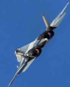 a fighter jet flying through a blue sky