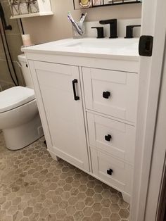 a bathroom with a toilet, sink and mirror