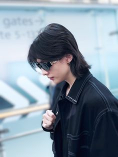 a man with black hair and sunglasses walking