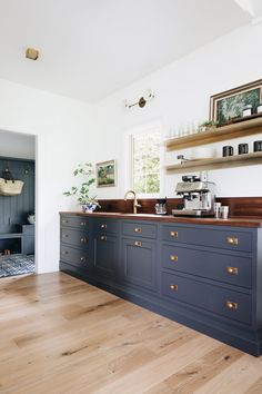 a kitchen with blue cabinets and wooden floors