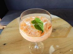 a close up of a drink on a table with a blue couch in the background