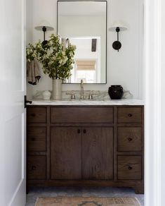 a bathroom with a large mirror above the sink and two lights on either side of it