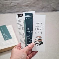 someone is holding up some books to show off their new bookmarks for the camera