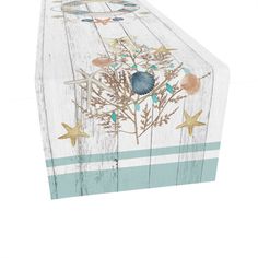 a wooden box with shells and starfishs painted on the side, sitting on top of a white surface