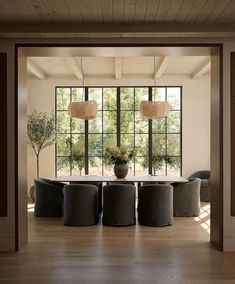 the dining room table is surrounded by black chairs and round tables with lamps on them