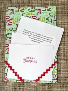 two envelopes with the words merry christmas written on them, sitting next to each other