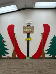 a room decorated with christmas trees and signs for canoe rentals on the side wall