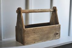 a wooden basket sitting on top of a window sill