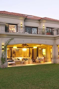 a large house with an outdoor living area in the front yard and patio at night