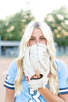 a woman with blonde hair wearing a catchers mitt