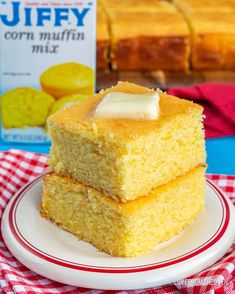 two pieces of cornbread on a plate with a carton of jelly in the background