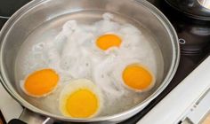 three eggs are being cooked in a pan on top of the burner and stove