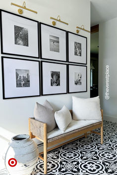 a living room with black and white flooring and pictures on the wall above it