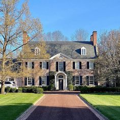 a large brick house surrounded by lush green grass