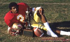 a football player laying on the ground with his trophy