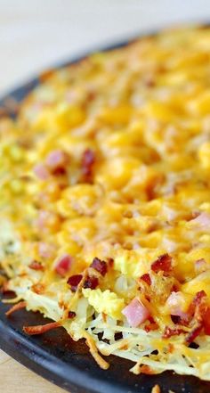 a casserole dish with cheese and bacon in it sitting on a counter top