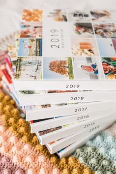 a pile of magazines sitting on top of a bed covered in crocheted blankets