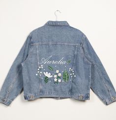 This personalized women's jean jacket is a stylish and special piece of clothing. Made from classic denim material, it's both durable and comfortable. Each jacket is meticulously designed and features unique embroidery elements. Whether it's your name, special patterns, or beautiful flowers, we can hand-embroider them on the jacket, making it a one-of-a-kind piece just for you. **Features - **High-Quality Denim Made from premium denim fabric, this jacket is sturdy and durable, yet soft and comfortable, perfect for all seasons. - **Customizable Designs You can choose to embroider names, flowers, or other designs you love, creating a unique style that belongs only to you. - **Versatile Use Whether for daily wear, friend gatherings, or special anniversaries, this jacket will make you stand ou Cheap Embroidered Cotton Denim Jacket, Trendy Denim Jacket With Floral Print, Spring Denim Jacket With Floral Print, Trendy Floral Print Denim Jacket, Spring Denim Jacket With Floral Embroidery, Embroidered Denim Jacket With Relaxed Fit, Embroidered Medium Wash Denim Jacket For Spring, Spring Embroidered Medium Wash Denim Jacket, Spring Denim Outerwear With Custom Embroidery