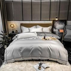 a bed with white sheets and pillows in a room next to a black wall,