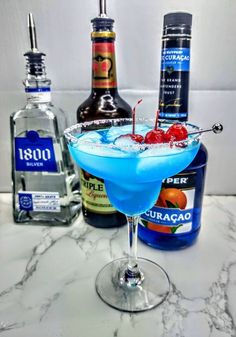 a blue cocktail garnished with cherries and vodka